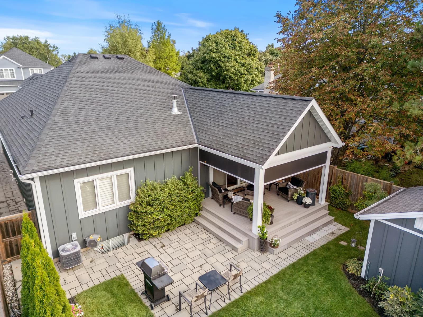 Aerial of gabled covered porch on a blue-sided suburban home