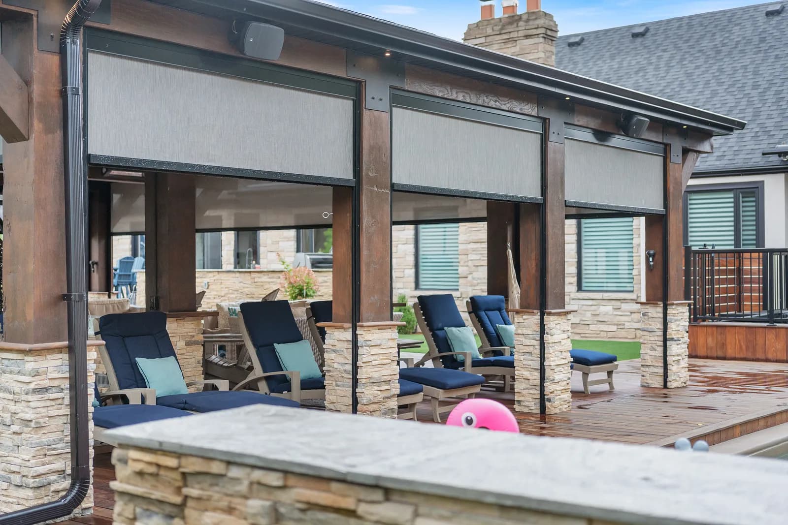 Pool-side cabana with multiple cream solar shades deployed against afternoon sun
