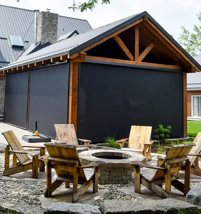 Timber-frame covered patio with retractable insect screens deployed around an Ontario fire pit