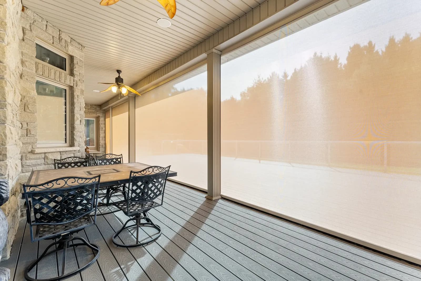 Stone patio at golden hour with cream solar mesh deployed