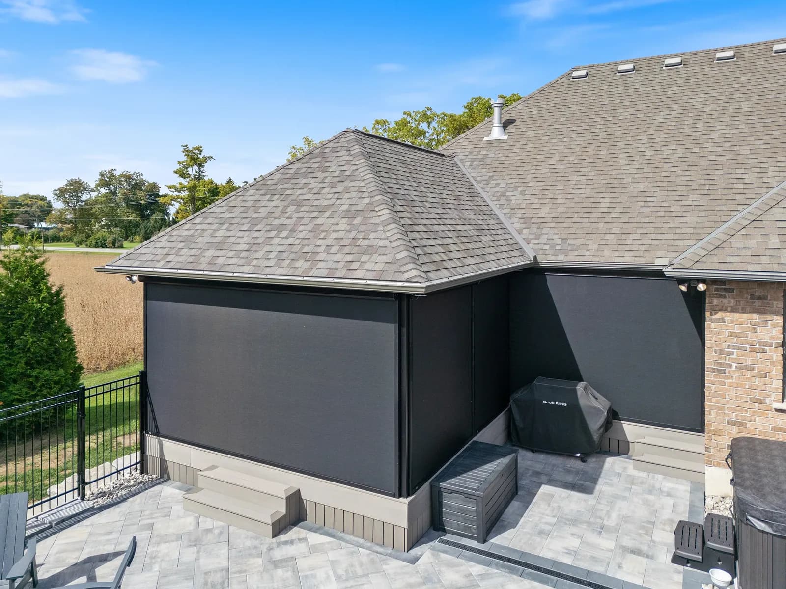 Stone-clad home with corner-mounted retractable screens deployed