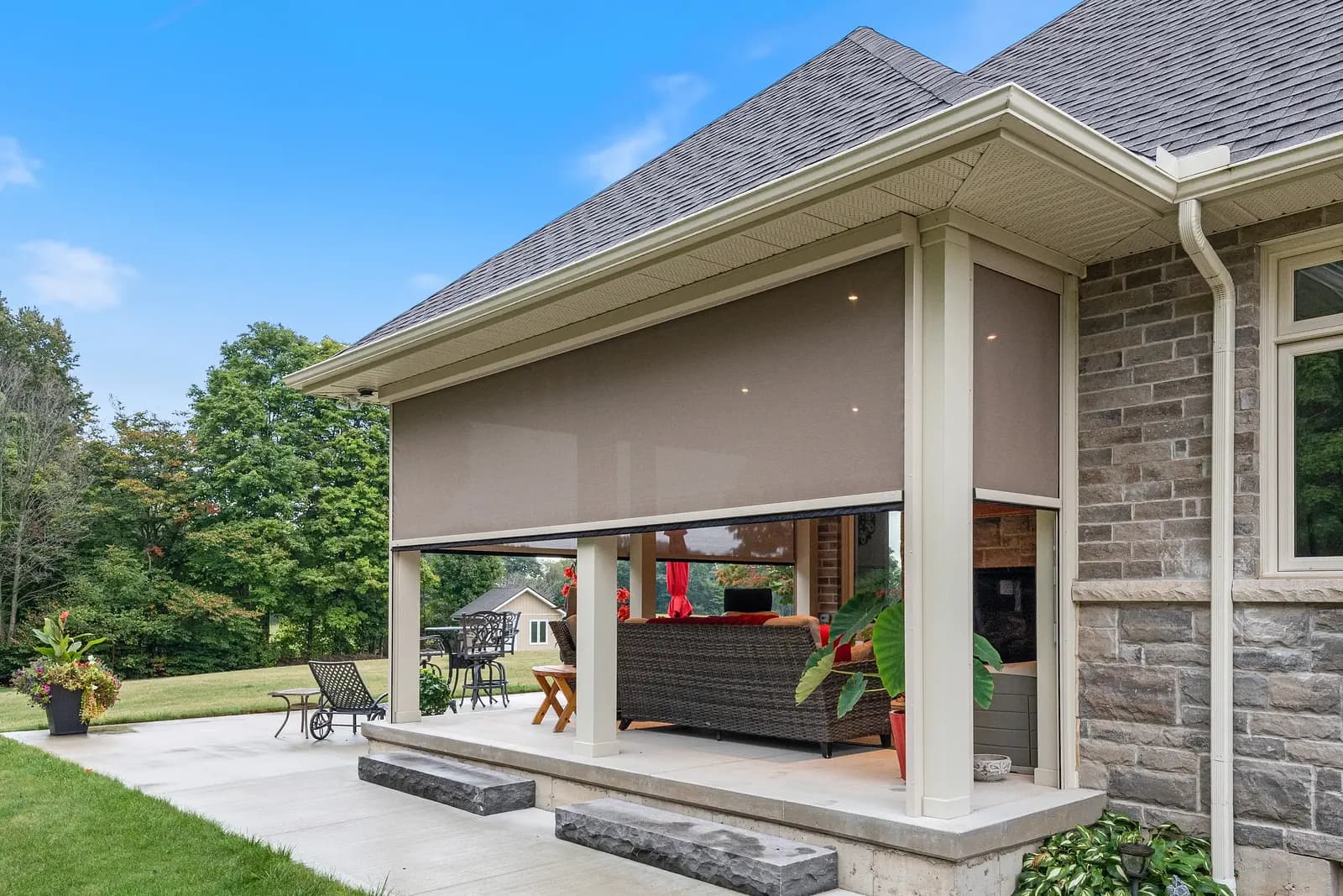 Stone home with deployed cream Habitat solar shade